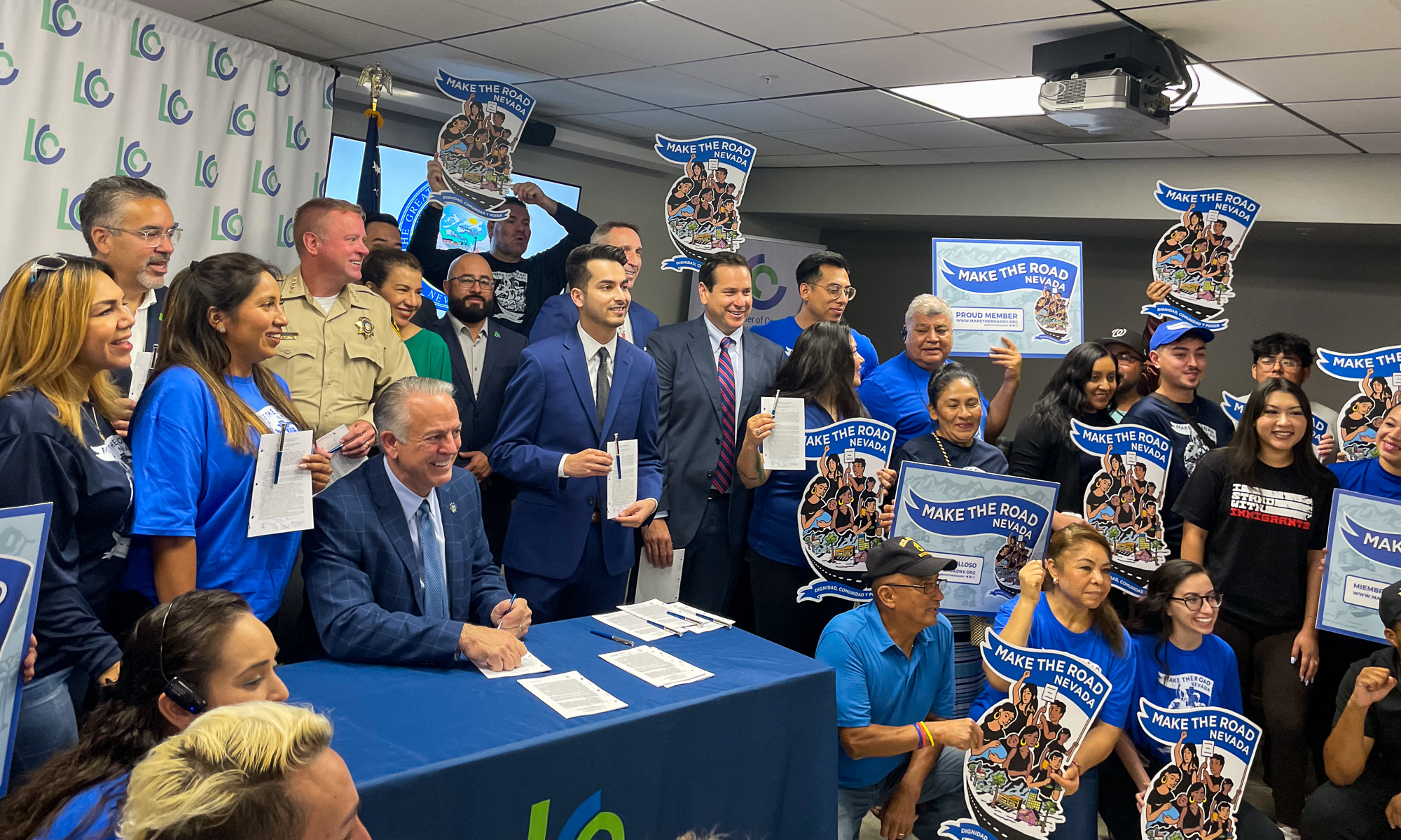 Gov. Joe Lombardo, state Sen. Fabian Doñate (D-Las Vegas) and Secretary of State Cisco Aguilar at a ceremonial bill signing for SB92, legalizing street food vendors while setting regulations, surrounded by members of immigrant advocacy group Make the Road Nevada at the Latin Chamber of Commerce in Las Vegas on July 18, 2023. (Jannelle Calderon/The Nevada Independent)