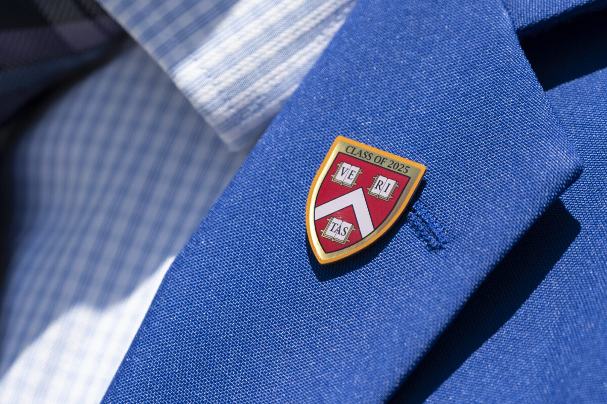 A pin given to all students upon entry to Harvard is seen on the lapel of John Cooke at his alma mater Rancho High School in Las Vegas on Monday, July 3, 2023. (Daniel Clark/The Nevada Independent).