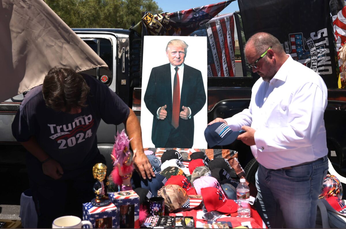 A vendor sells former President Donald Trump souvenirs outside Fervent: A Calvary Chapel Church during a volunteer outreach event in Las Vegas on Saturday, July 8, 2023. (Jeff Scheid/The Nevada Independent)