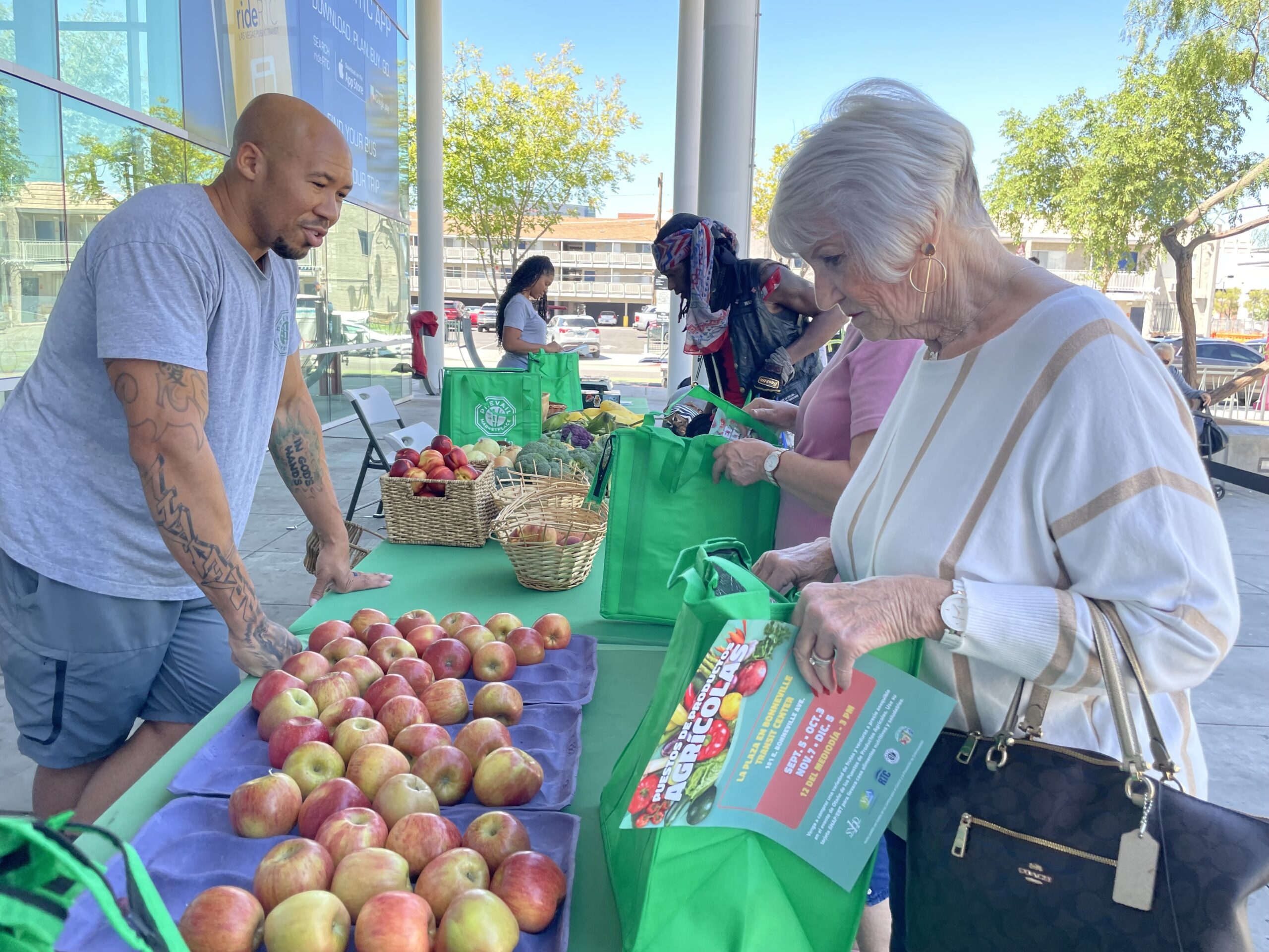 older woman shopping for apples at an outdoor market