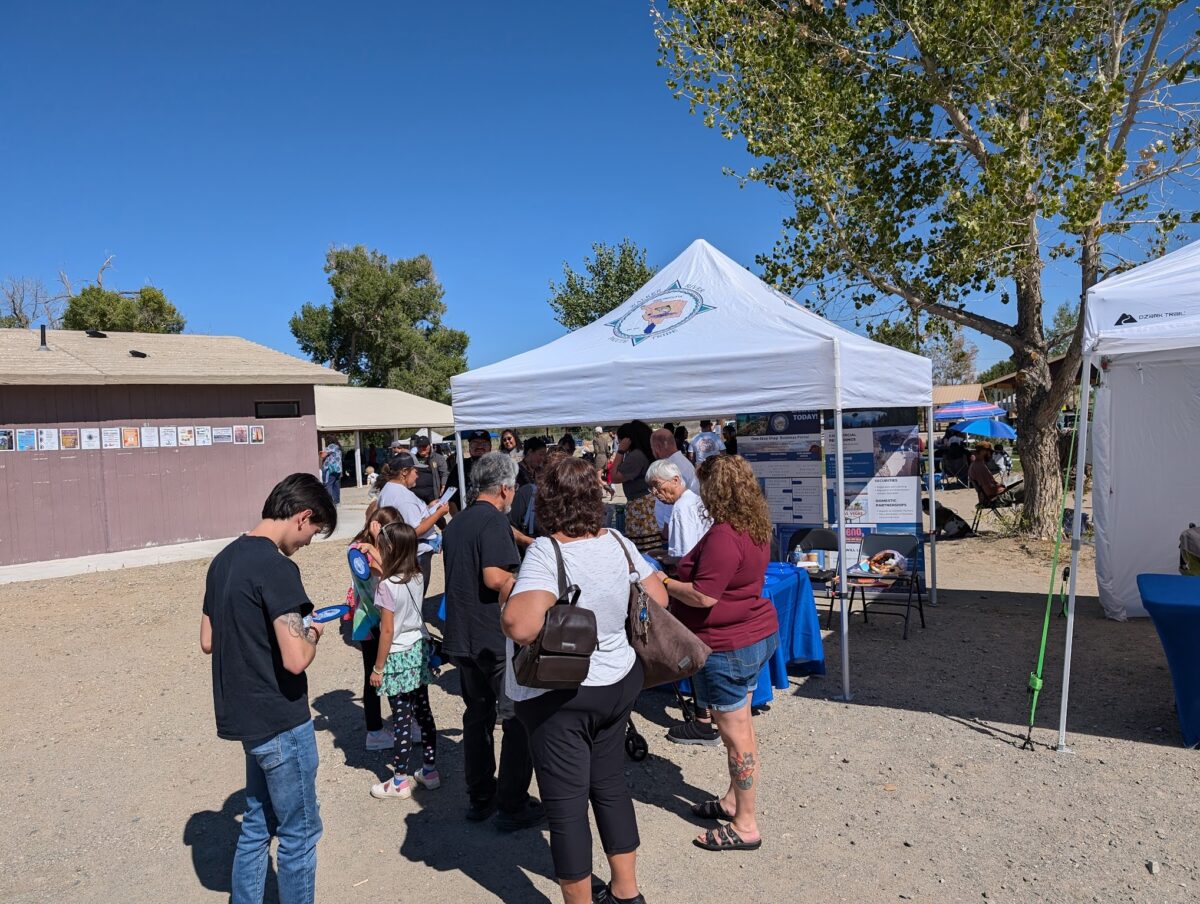 People stand in a line at a booth with voting information at the Walker River Paiute Tribe’s 93rd annual Pinenut Festival in Schurz on Sept. 21, 2024 (Photo courtesy of the Nevada Secretary of State's Office).