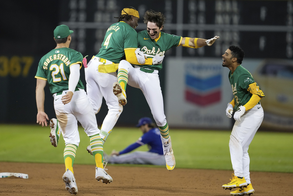 Oakland Athletics' Jacob Wilson, center right, is congratulated by Lawrence Butler (4) after hitting the game-winning RBI single during the ninth inning of a baseball game against the Texas Rangers.