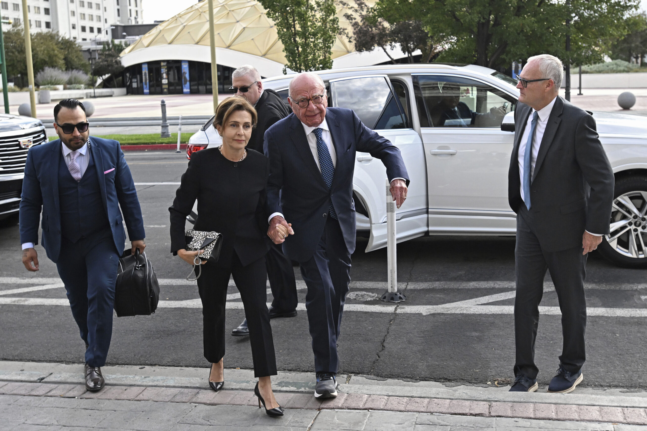 Rupert Murdoch, center, and his wife Elena Zhukova Murdoch arrive at the Second Judicial District Court in Reno, Nev.