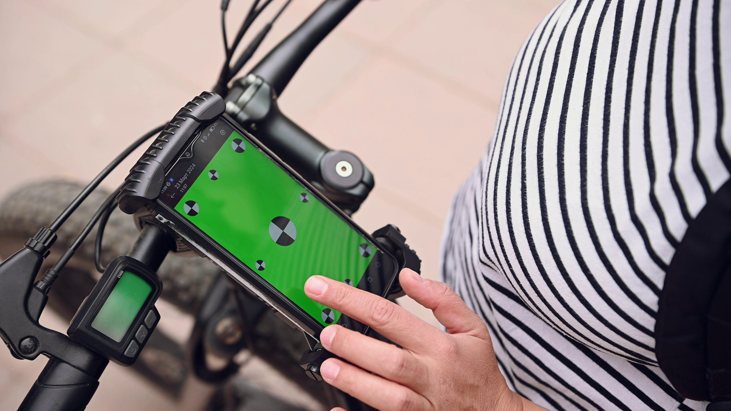 A cyclist uses a smartphone app to set a route on an e-bike.