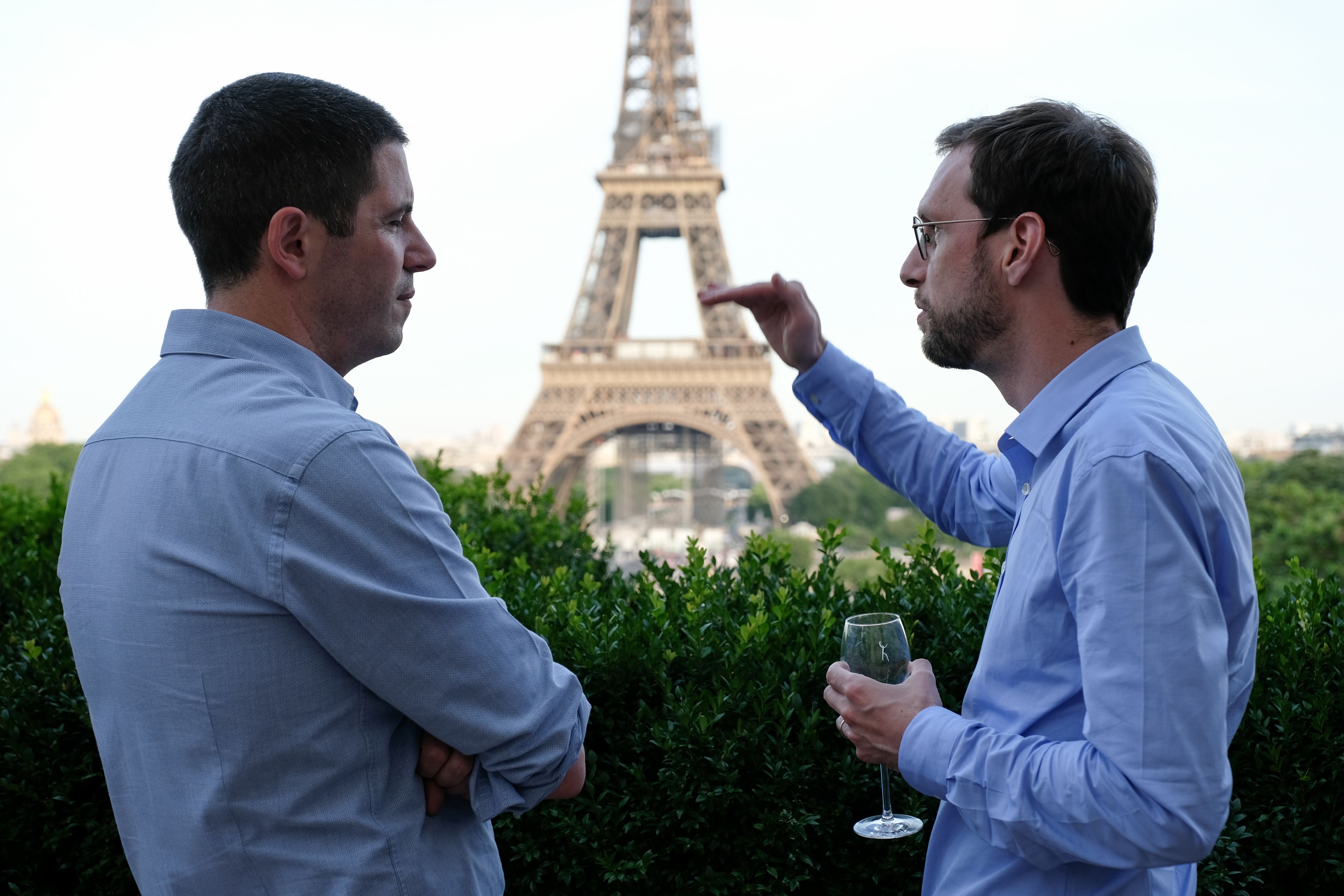 two men networking in front of eiffel tower
