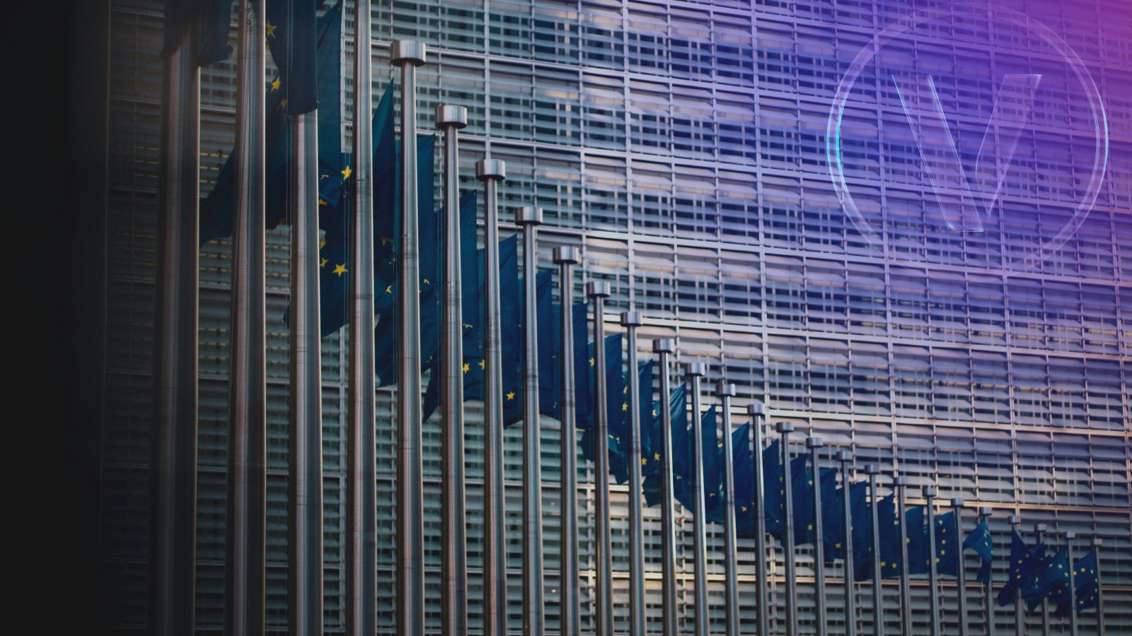 Row of European Flags in front of glass building 