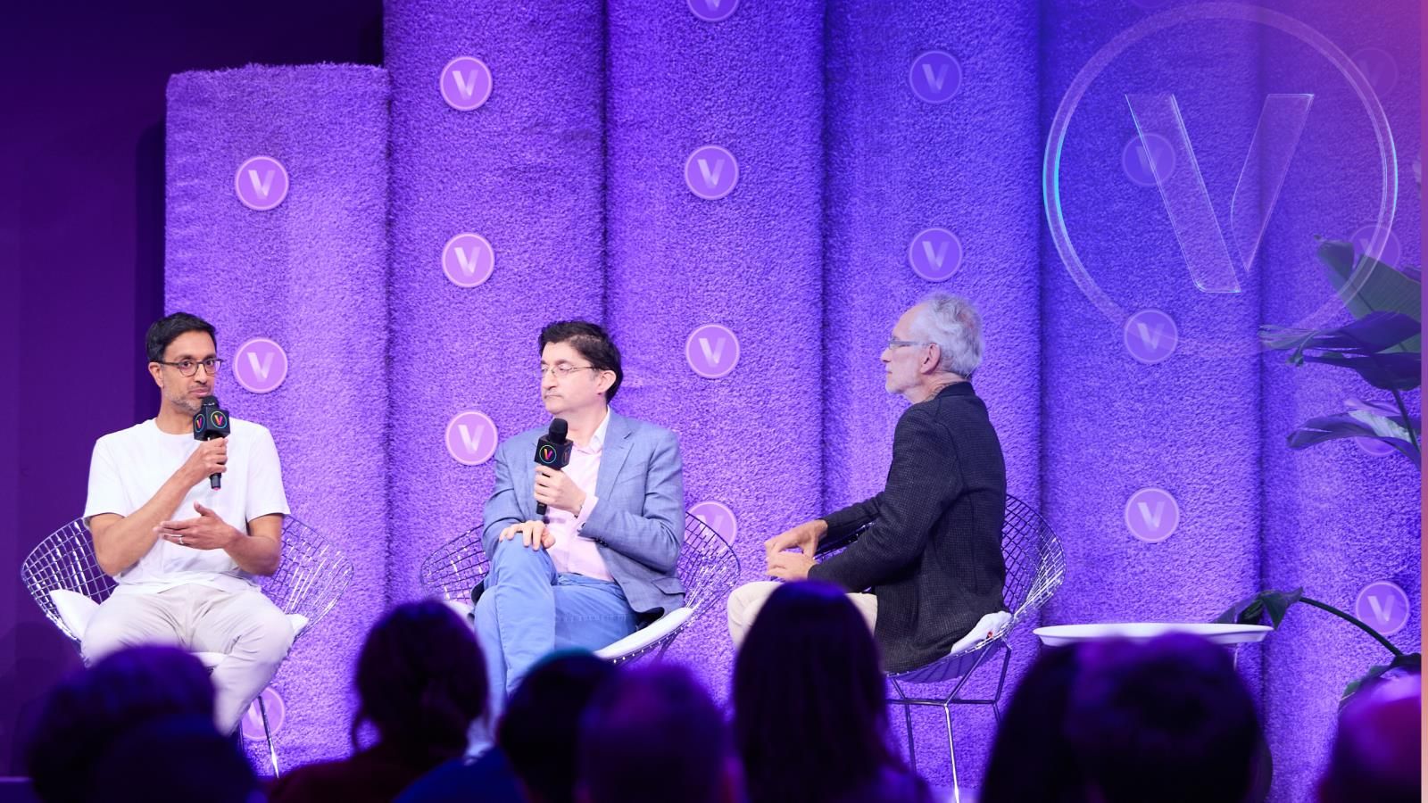 Three speakers sitting on stage