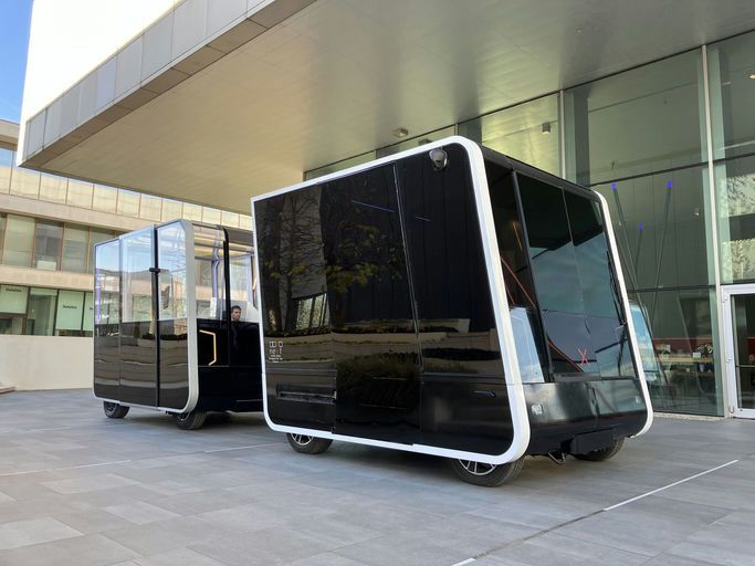 a black, square vehicle in front of a building