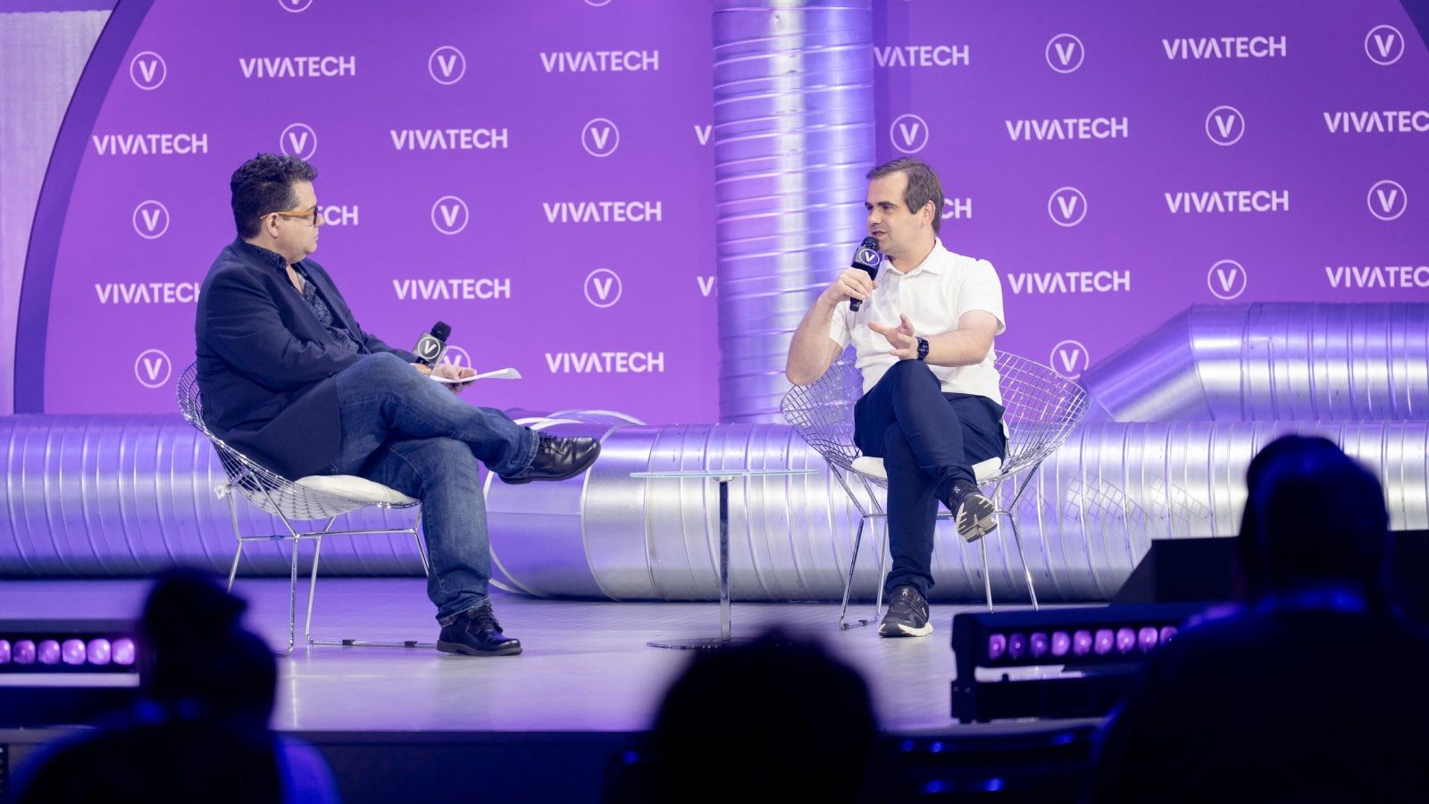 Chris O'Brien (left) and Jarek Kutylowski (right) sitting on the purple stage at VivaTech