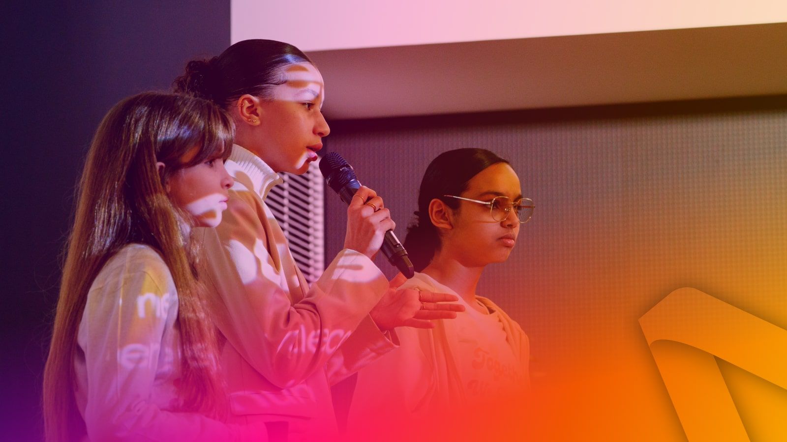 3 girls talking on stage