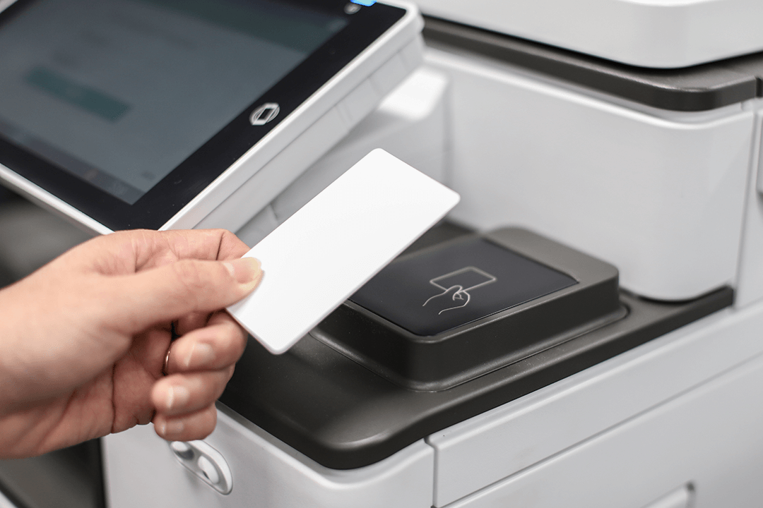 Close up photo of a card reader, with a hand holding a swipe card just above the card reader.