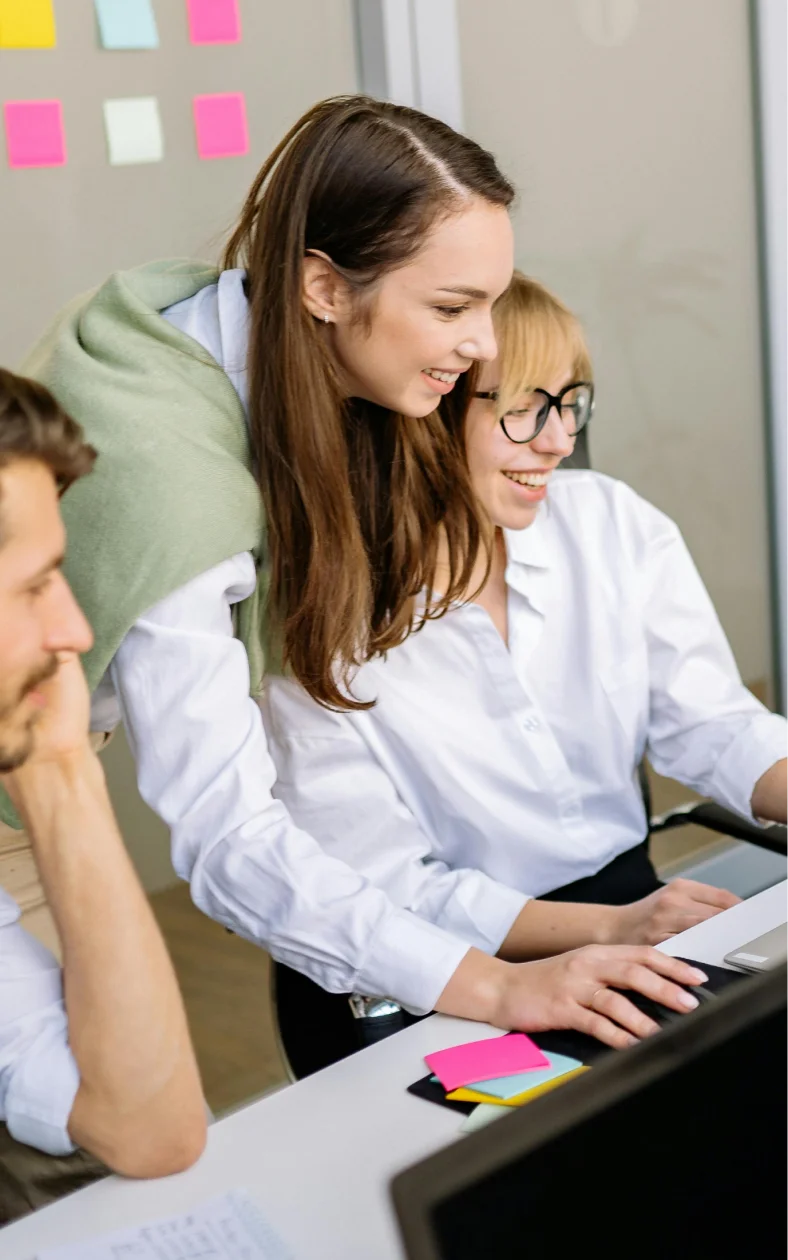 3 office workers looking at a computer