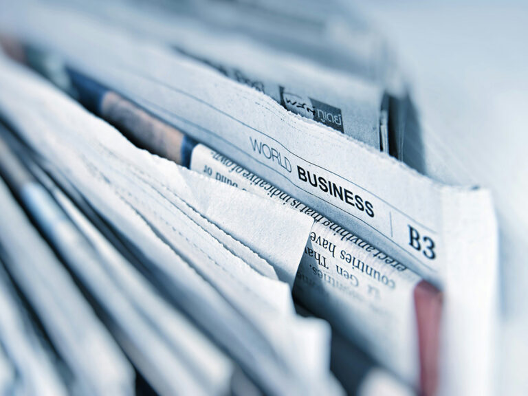 stacks of newspapers from different news agencies