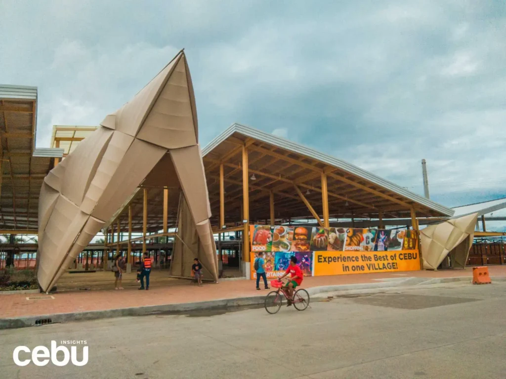 Entrance of the Puso Village with a few customers and a man on a bike in front of it