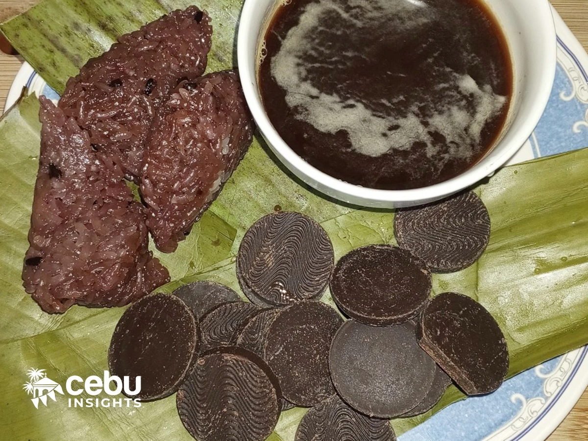 A picture of puto sikwate consisting of puto maya, tablea (cacao tablets), and a cup of hot cocoa.
