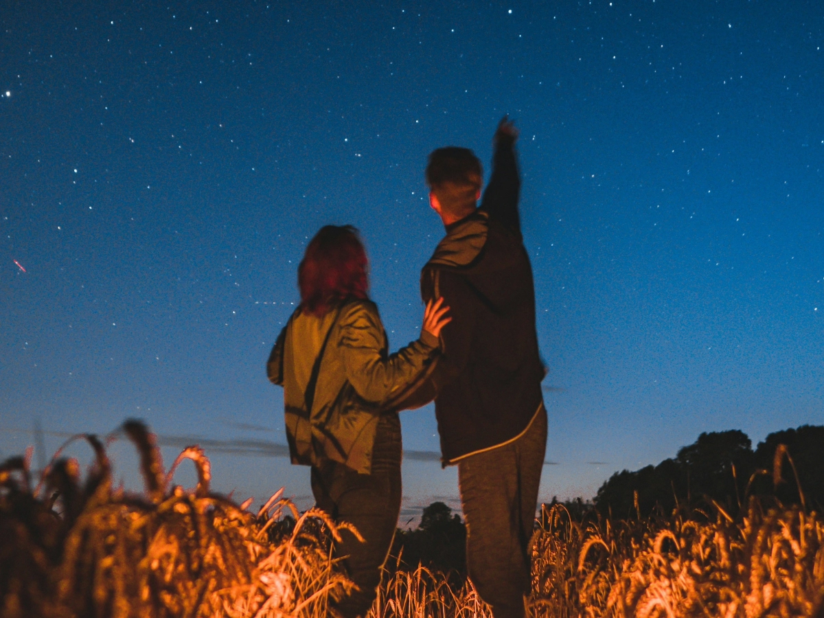 Man and woman stargazing in an open field, one of the many things to do in Cebu at night