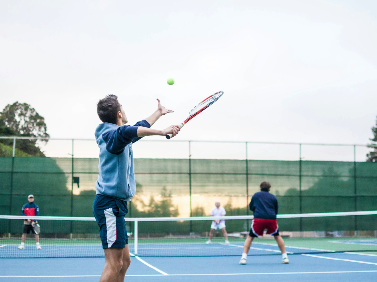 A man serving during a game of tennis, one of the most popular racket sports in the world