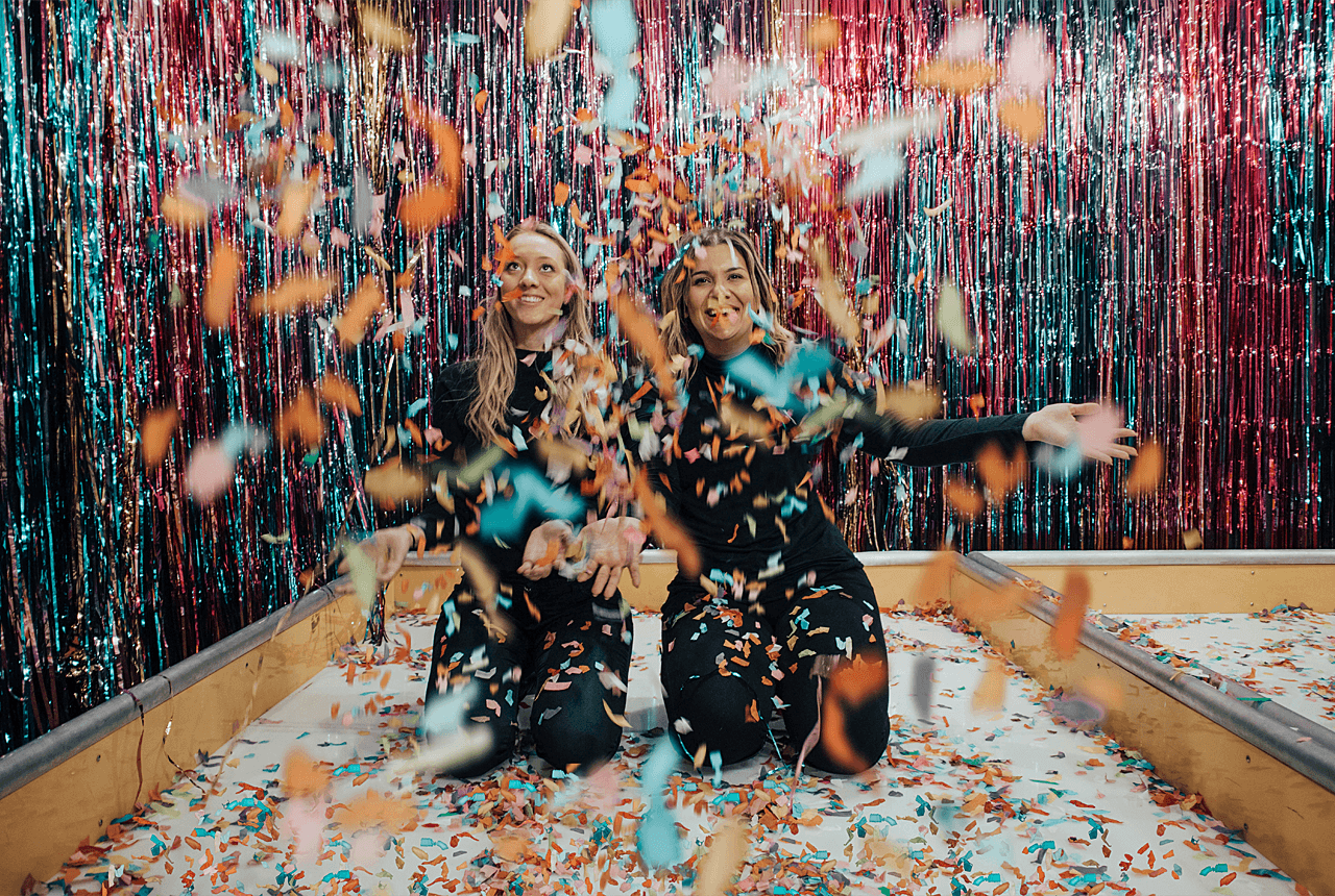 two women celebrating with confetti