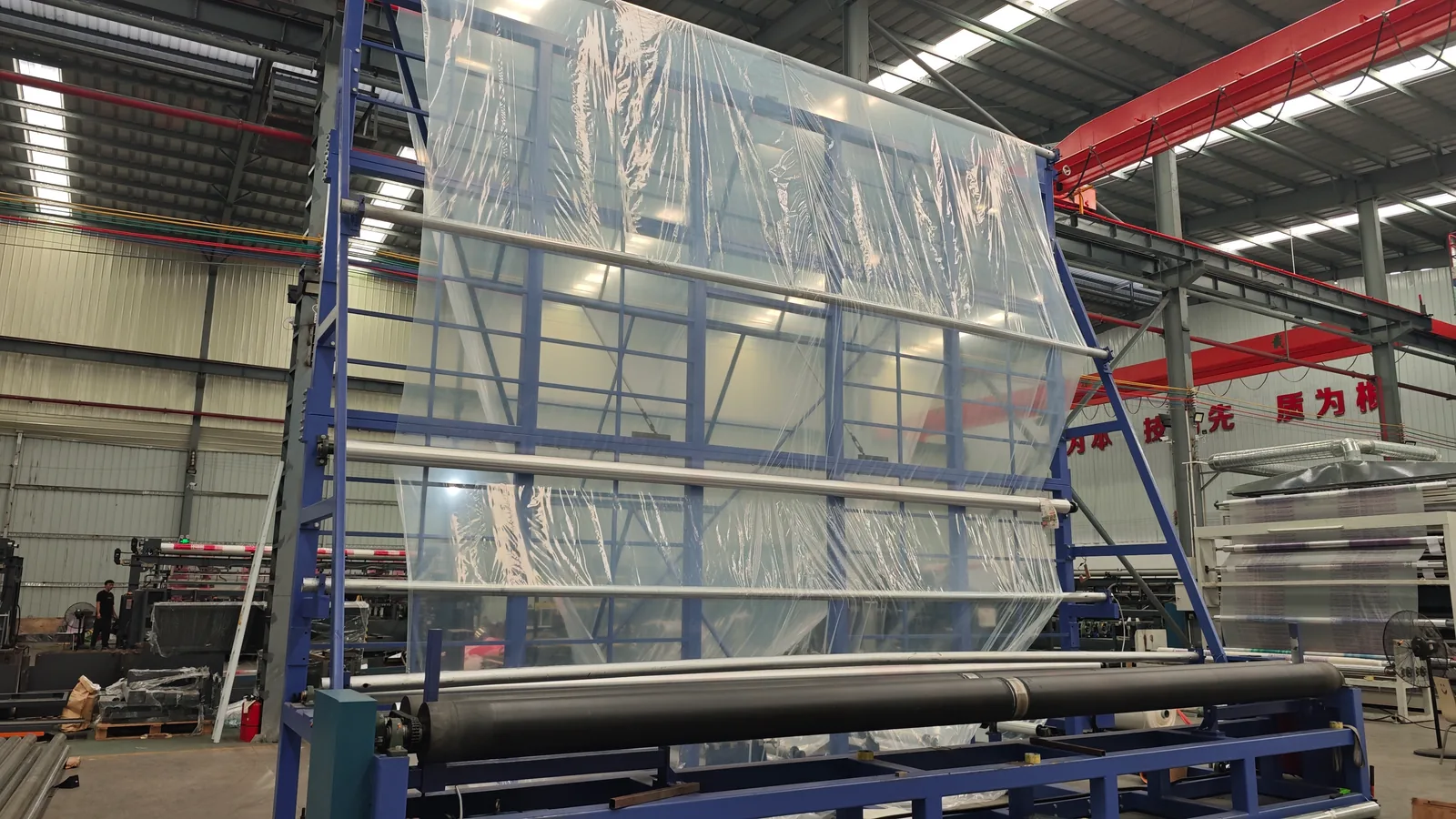 Clear film threaded through a tall frame in the workshop