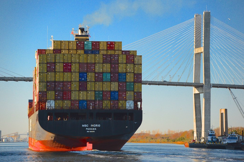 A huge container ship sails under the bridge from Savannah, Georgia into South Carolina, as it prepares to unload its cargo imported from the far east.