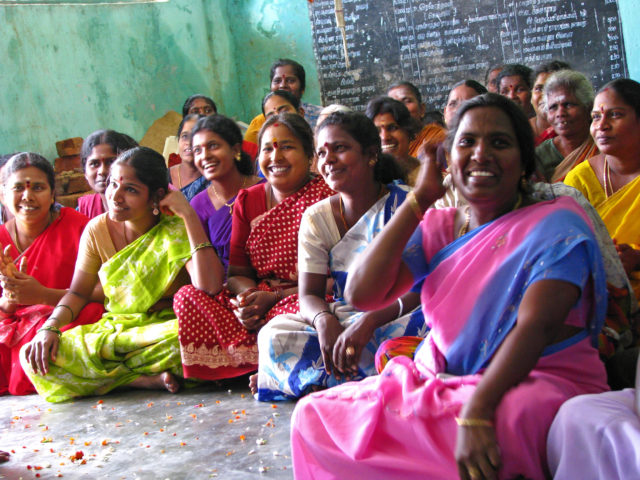 Rural women in their richly coloured saris meeting as members of self-help groups (SHGs).