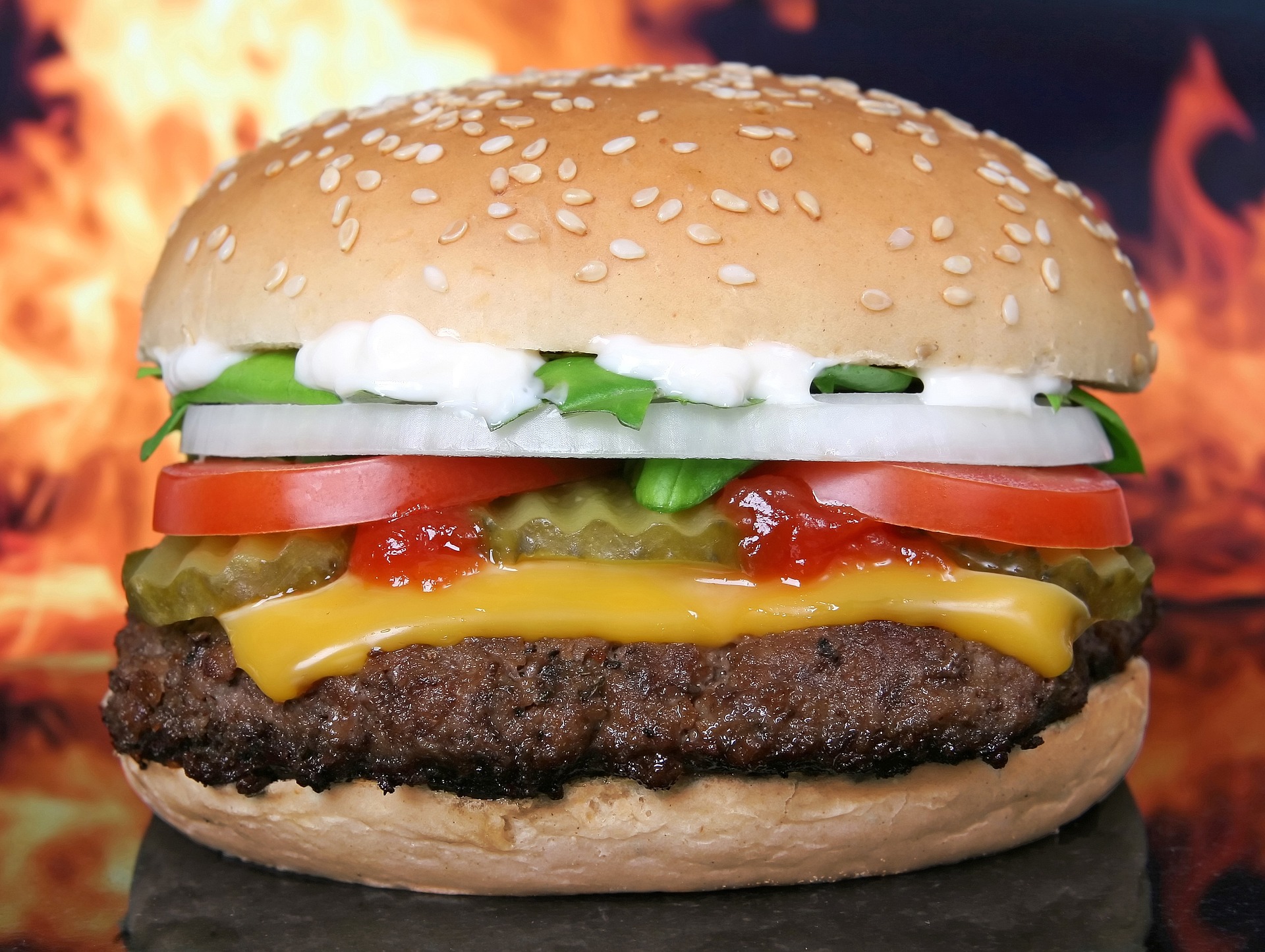 Hamburger in front of flames, McDonald's, KFC, Burger King, Domino's are being asked by investors to curb their carbon emissions and water usage across their supply chains