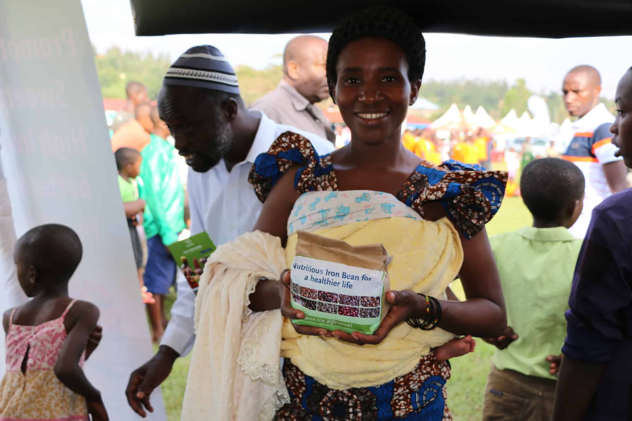 A woman holds a package of iron-biofortified beans at a Rwandan agricultural fair. A new study shows that providing such beans to iron-deficient women in Rwanda improved their ability to perform physical work.