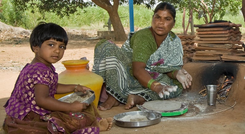 A mother prepares flat bread from pearl millet in Andhra Pradesh, India