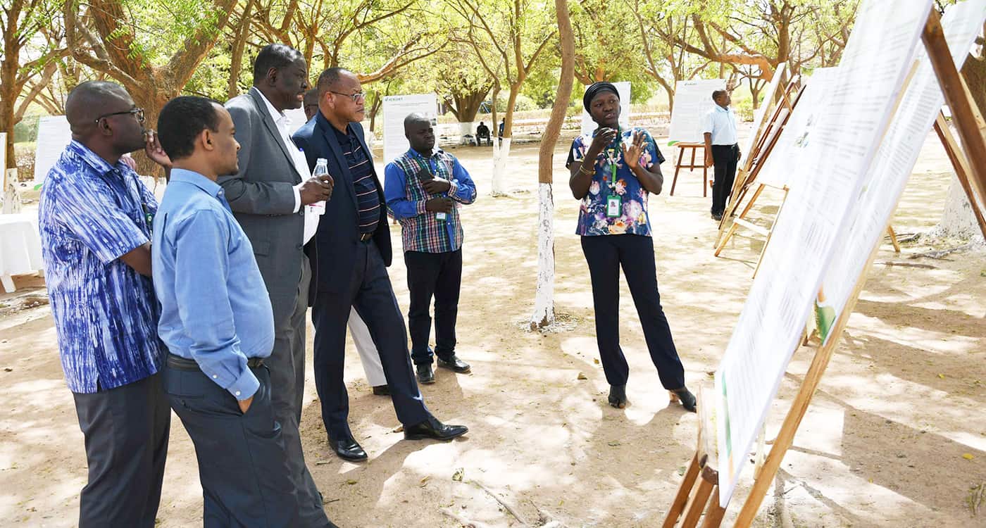 Dr Paco Sereme, Chair of the ICRISAT Governing Board and Dr Ramadjita Tabo, Research Program Director, WCA watching a poster presentation by phd student Ms Madina Diancoumba along with other scientists. Photo: N Diakite, ICRISAT