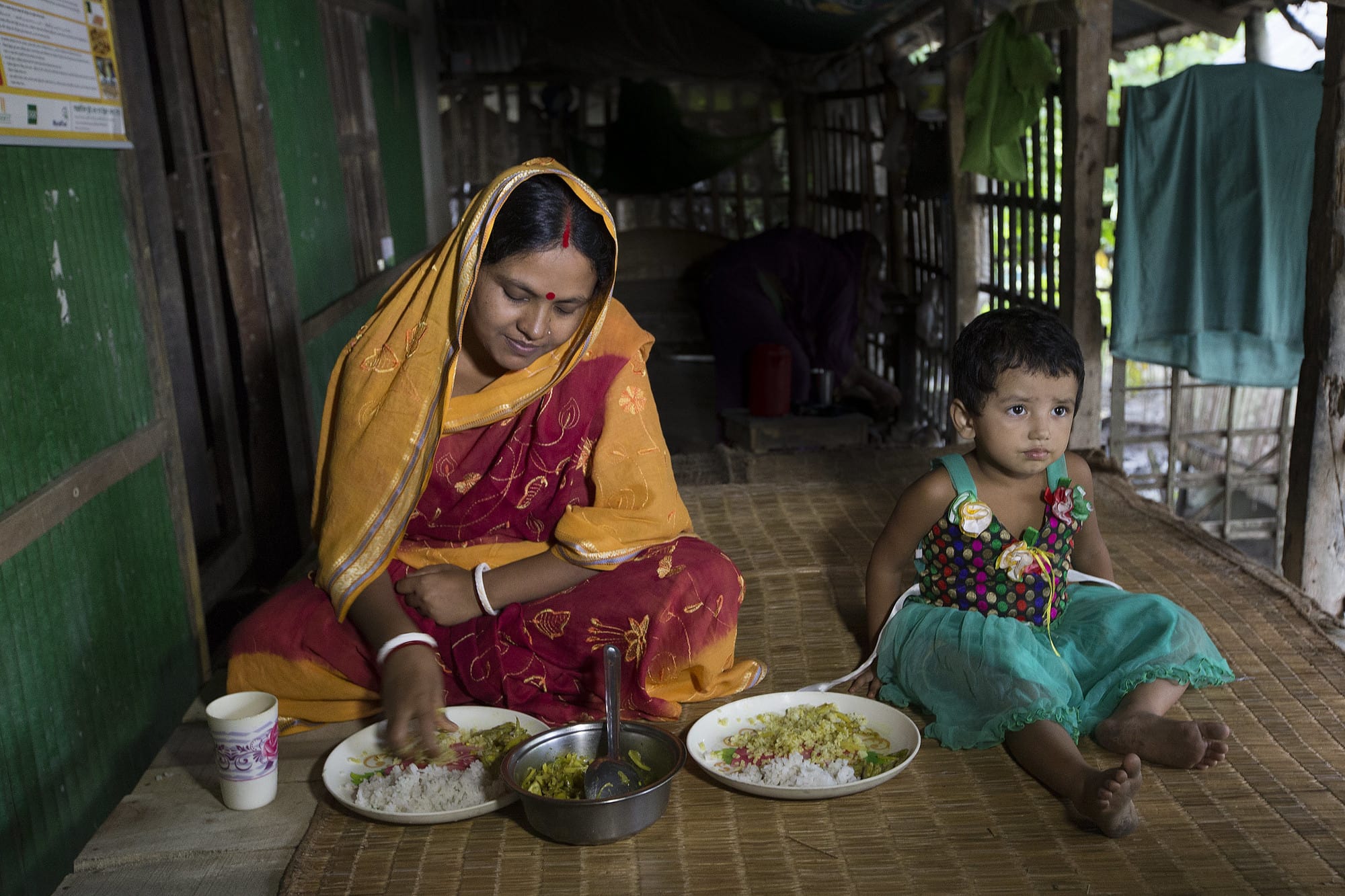 A woman and her daughter eat a healthy meal in Khulna, Bangladesh. Photo by Yousuf Tushar.