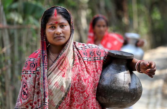 Komola Roy carries drinking water in Fultola Village, Khulna, Bangladesh. Photo by M. Yousuf Tushar.