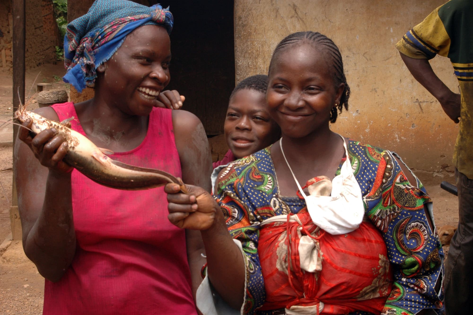 Fisherwomen hold a catfish harvested from their pond in Cameroon. Photo by Randall Brummett.