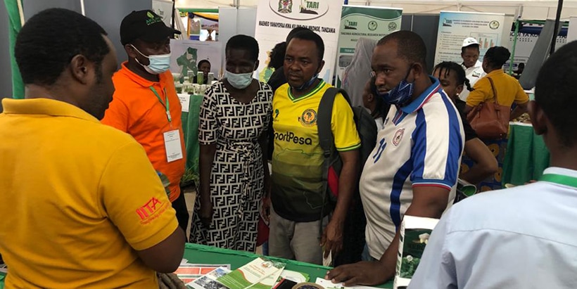 ACAI Agronomist Abubakari Mzanda speaking with visitors at the exhibition.