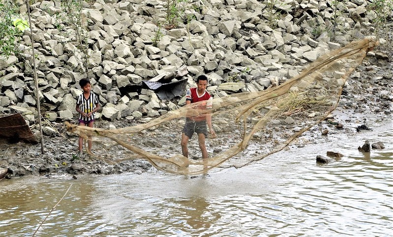 Fisherman and son fishing in the Twante Canal, Myanmar. Photo by Michael Akester.