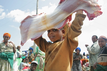 A girl carries a slab of beef in Goro town, Ethiopia, on market day (photo credit: ILRI/Stevie Mann).