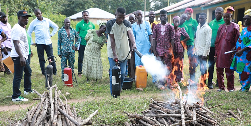 Fire Safety Officer Sola Ayinde demonstrating how to extinguish fire safely.