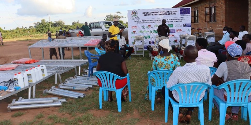 Dalson Twecan, the production specialist from IITA (In a yellow shirt) handing over the technology equipment to farmers of Awrotcek subcounty Amolatar district. Photo credit: Moureen Awori