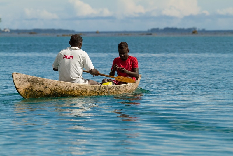 Men paddle out to reef to catch fish in the Solomon Islands. Photo by Filip Milovac.