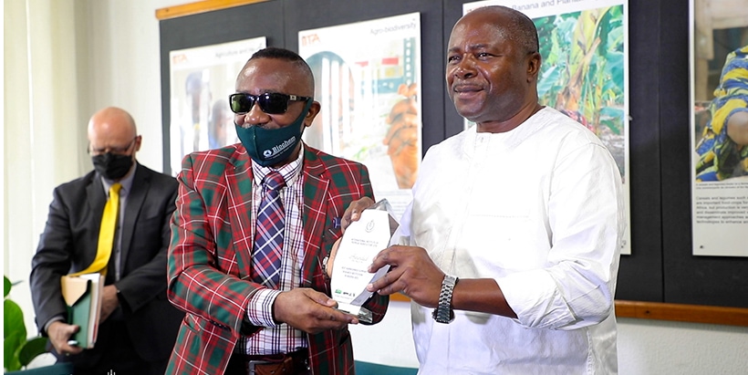 Africa Farming Project National Coordinator Dr Bright Isaac Okwu (left) presenting the award to DG Sanginga.