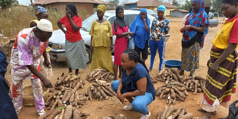 Obafunsho (squatting) in an open market at Igbaiye community in Osun State, with women cassava processors and buyers.