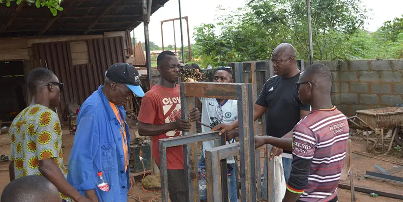 Postharvest Engineer Thierno Diallo (second from left) overseeing the wet hammer mill fabricators.