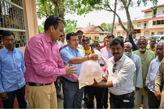 Munindra Nath Ngatey handing over oxygen-packed bags of mola seeds to farmers. Photo: Sourabh Kumar Dubey