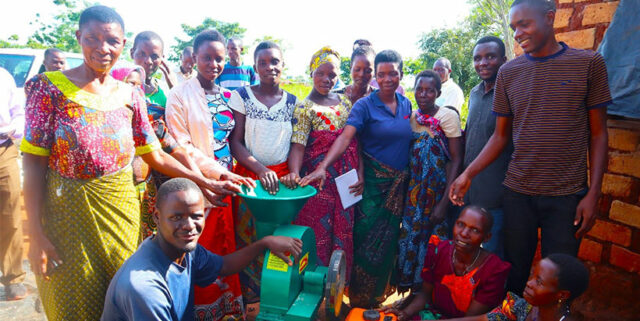 Excited small-scale processor group members with a sunflower oil press.