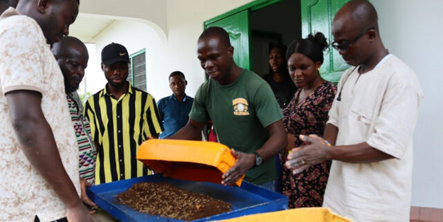 Processors learning how to use one of the cassava milling machines.