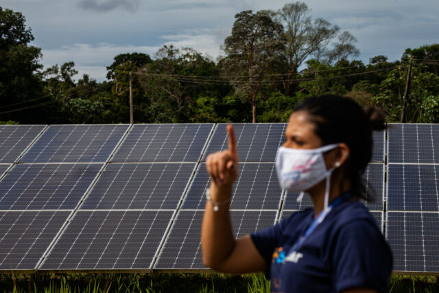 Brazilian woman in front of solar panels.