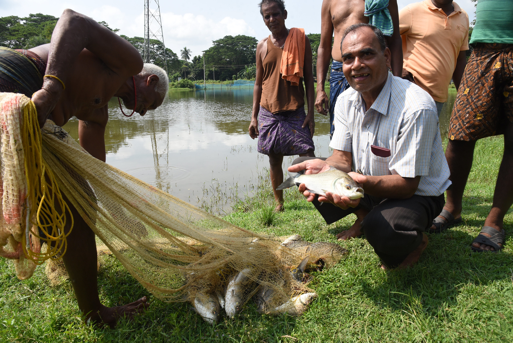 Farmer Bibhuti Bhusan Dash holding a carp from a community pond in Dhuanpari village, Jagatsinghpur district, Odisha, India.