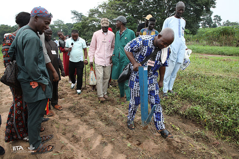 One of the farmer-beneficiaries practicing with a manual planter on the field.