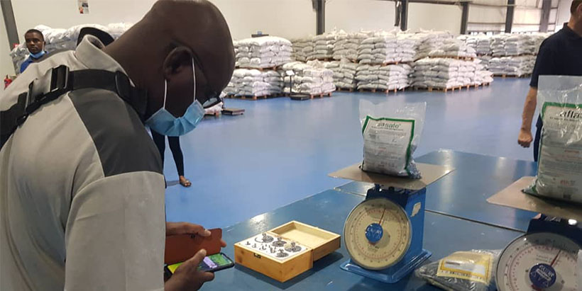 Institute of Rural Economy (IER-Mali) official Mamadou Konate examines a pack of Aflasafe produced by Harvestfield Industries Limited (HIL), the licensed manufacturer and distributor of Aflasafe in Nigeria. During the visit, HIL staff underscored the importance of reliable biocontrol products with long shelf-life in effective aflatoxin mitigation.