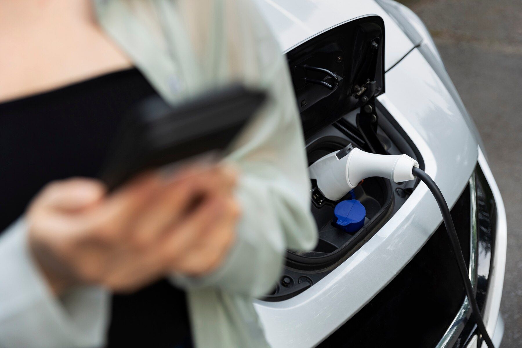 woman-using-her-smartphone-while-electric-car-is-charging_23-2149458105.jpg