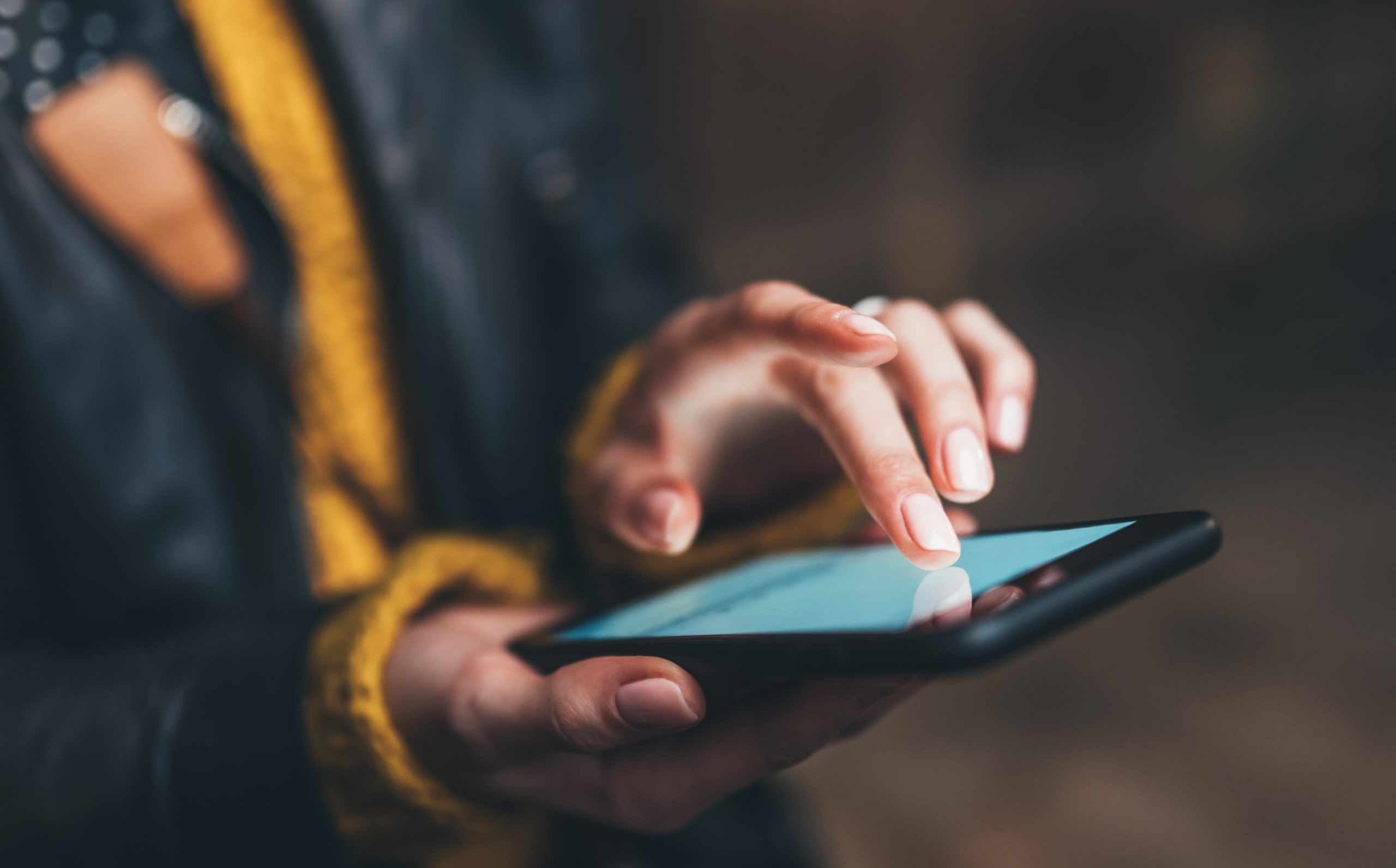 A woman on her phone pressing a widget on a website.